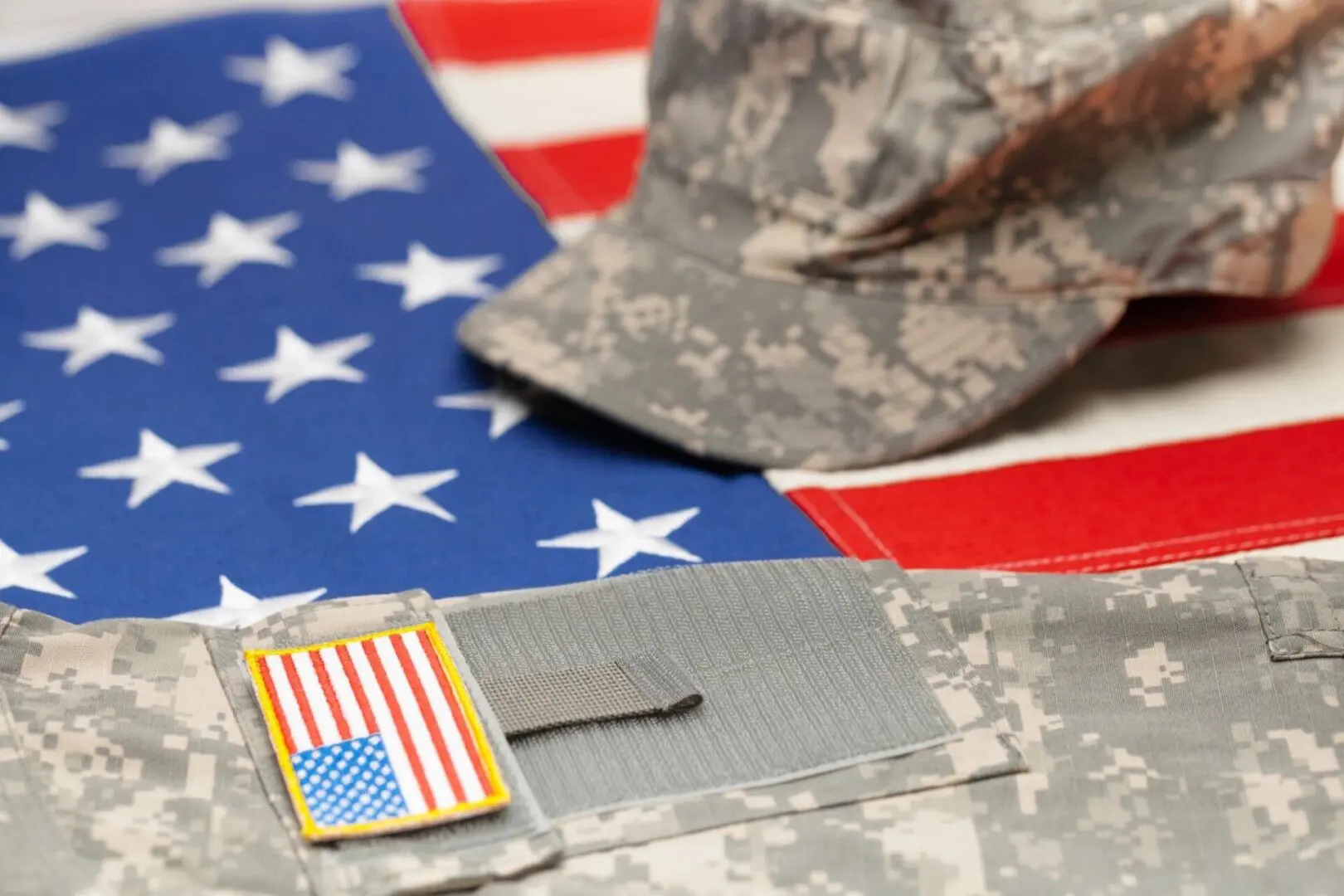 Military uniform and cap on American flag.