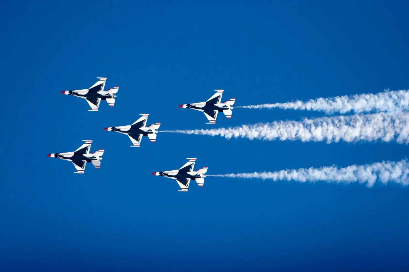 Five jets flying with smoke trails.